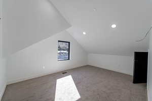 Additional living space featuring light colored carpet, recessed lighting, and vaulted ceiling