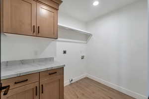 Laundry room featuring light wood-style floors, washer hookup, recessed lighting, cabinet space, and hookup for an electric dryer