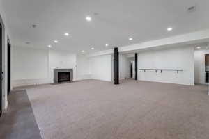 Unfurnished living room featuring recessed lighting, a fireplace, and carpet flooring