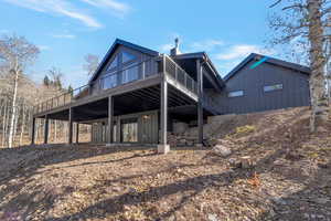 Back of house with a deck and board and batten siding