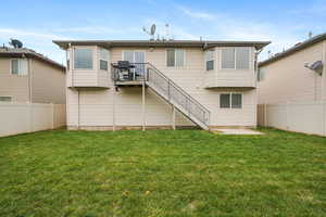Back of property featuring a fenced backyard, a patio area, stairway, and a deck