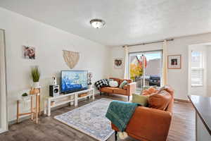 Living room with wood finished floors and a textured ceiling