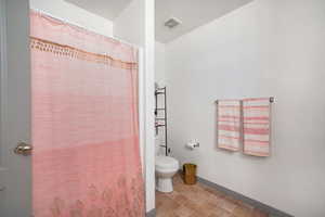 Full bath with curtained shower and toilet