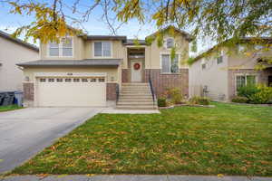 View of front of home featuring stucco siding, concrete driveway, a garage, and brick siding