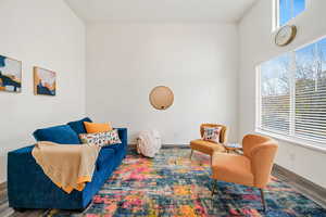 Living area featuring wood finished floors and a towering ceiling