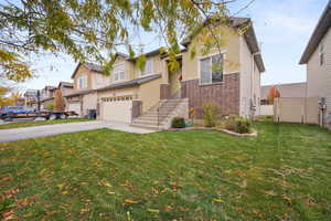 View of front of property with concrete driveway, brick siding, a garage, stucco siding, and a residential view