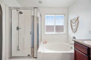 Full bathroom with vanity, a garden tub, and a stall shower