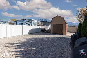 Fenced backyard with a storage shed and a mountain view