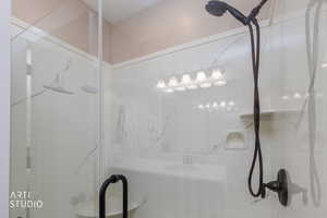 Full bath with a marble finish shower