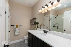 Bathroom featuring vanity and a marble finish shower