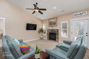 Living area featuring vaulted ceiling, a fireplace, ceiling fan, recessed lighting, and carpet flooring