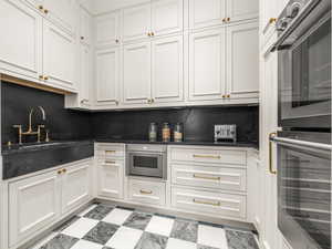 Kitchen pantry featuring double ovens and custom cabinetry