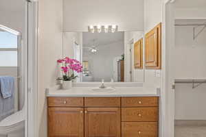 Primary bath featuring a spacious closet, vanity, an enclosed shower, light tile patterned flooring
