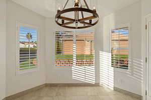 Unfurnished dining area featuring a chandelier and tile patterned floors