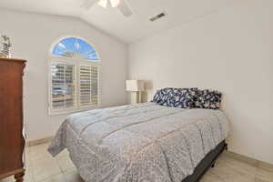 Bedroom featuring lofted ceiling, ceiling fan, and light tile patterned floors