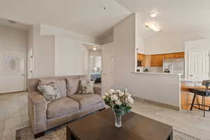 Living area featuring light tile patterned flooring and high vaulted ceiling