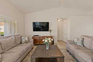 Tiled living area featuring lofted ceiling