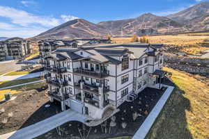 View of home's exterior with a mountain view, a balcony, and stone siding