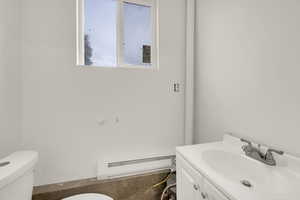 Half bathroom featuring a baseboard heating unit and vanity