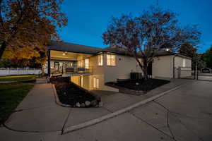 Back of property with a gate, brick siding, and a porch