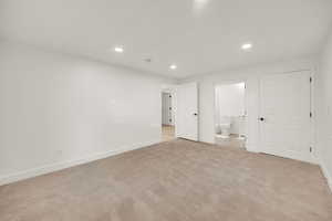 Unfurnished bedroom featuring recessed lighting, light carpet, and ensuite bathroom