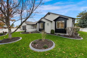 Modern farmhouse with board and batten siding, brick siding, an attached garage, and driveway