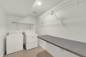 Laundry area featuring washer and clothes dryer and finished concrete flooring