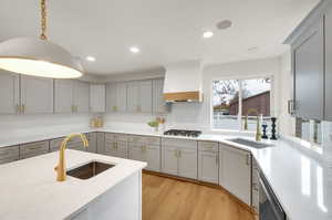 Kitchen featuring pendant lighting, light wood-style floors, recessed lighting, gray cabinetry, and light stone countertops