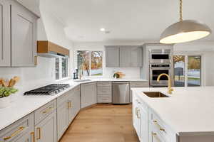 Kitchen featuring gray cabinets, light stone countertops, decorative light fixtures, stainless steel appliances, and recessed lighting