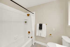 Full bath with shower / bathtub combination with curtain and light tile patterned flooring