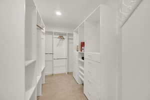 Walk in closet with light carpet