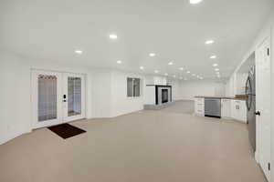 Unfurnished living room with recessed lighting, a glass covered fireplace, and french doors