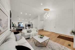 Living area with recessed lighting, lofted ceiling, and light wood-style floors