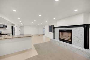 Unfurnished living room featuring recessed lighting and a high end fireplace