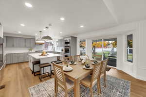 Dining area with light wood-type flooring and recessed lighting