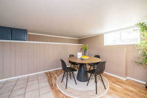 Dining room with wood walls and light wood finished floors