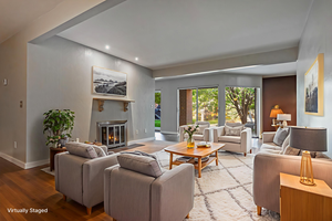 Living room featuring wood finished floors, a fireplace with flush hearth, and recessed lighting