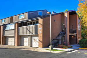 View of property featuring an attached garage and stairway