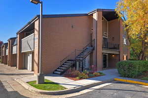 View of building exterior featuring stairs and an attached garage