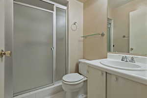 Bathroom with light tile patterned floors, vanity, and a shower stall