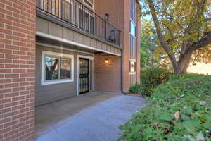 Property entrance with a patio area and brick siding