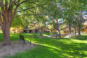 View of grassy yard featuring stairway, a water view, and a balcony
