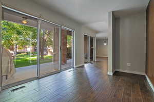 Spare room featuring dark wood-style flooring and baseboards