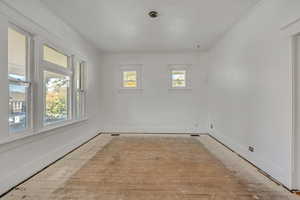 Unfurnished room with hardwood / wood-style floors and ornamental molding