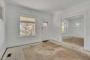 Foyer entrance featuring ornamental molding and light wood-style flooring
