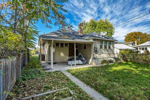 Back of property with a fenced backyard, a gate, a chimney, and a patio area