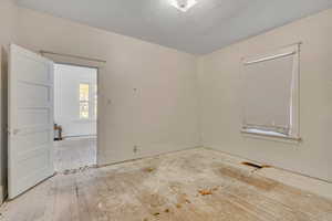 Spare room with hardwood / wood-style floors and a textured ceiling
