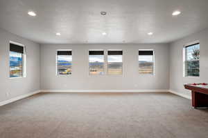 Empty room featuring plenty of natural light, light colored carpet, and recessed lighting