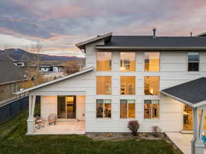 Rear view of property with roof with shingles, a patio, and a mountain view