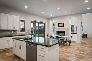 Kitchen with recessed lighting, white cabinetry, dishwasher, dark wood-style floors, and open floor plan